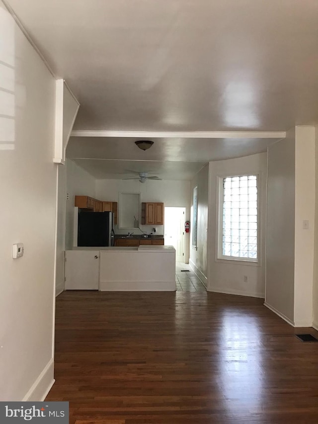 unfurnished living room featuring dark hardwood / wood-style flooring and ceiling fan