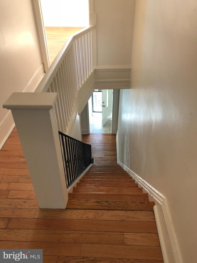 stairs featuring hardwood / wood-style floors