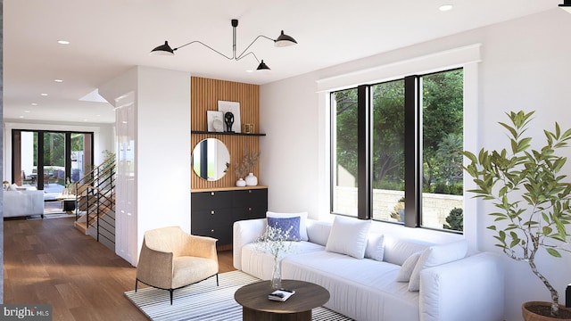 living room with a healthy amount of sunlight, dark hardwood / wood-style flooring, and an inviting chandelier