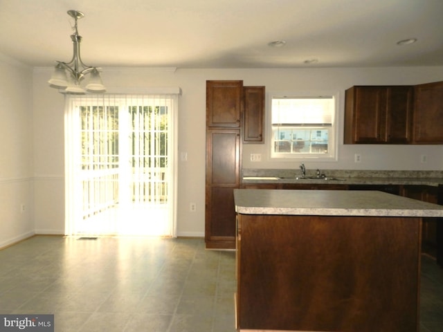 kitchen featuring sink, a center island, a chandelier, and decorative light fixtures