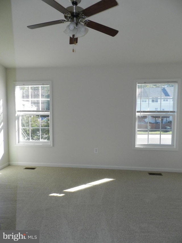 carpeted spare room with ceiling fan