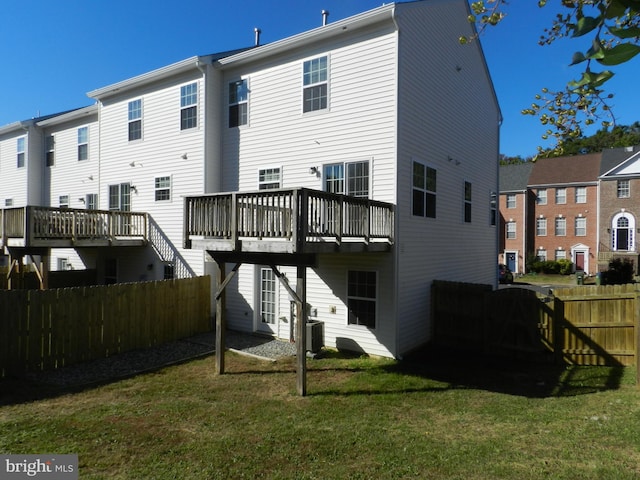 back of property with a lawn, a deck, and central air condition unit