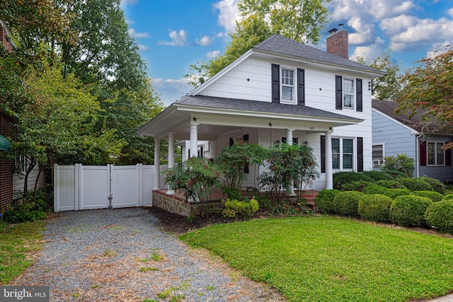 view of front facade with covered porch and a front yard