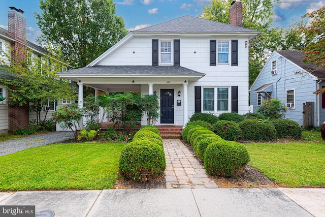 view of front of house with a front yard and covered porch