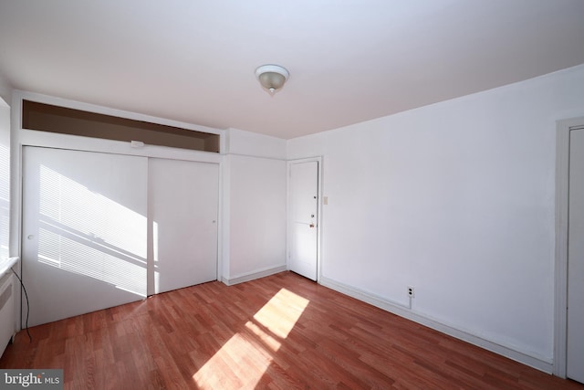 unfurnished bedroom featuring a closet and hardwood / wood-style flooring