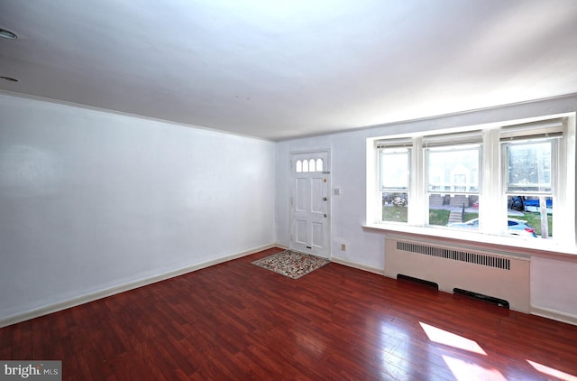 entryway with dark wood-type flooring and radiator