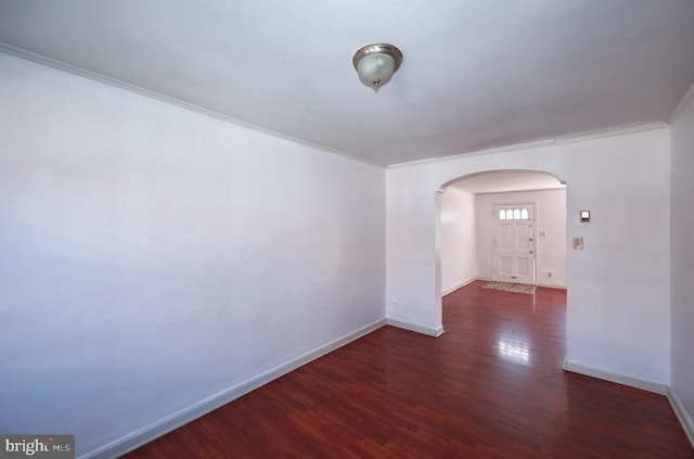 spare room featuring ornamental molding and dark wood-type flooring