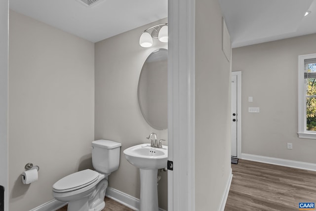 bathroom with toilet, sink, and wood-type flooring