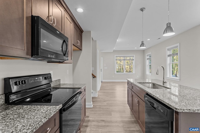 kitchen with sink, black appliances, a wealth of natural light, and light wood-type flooring