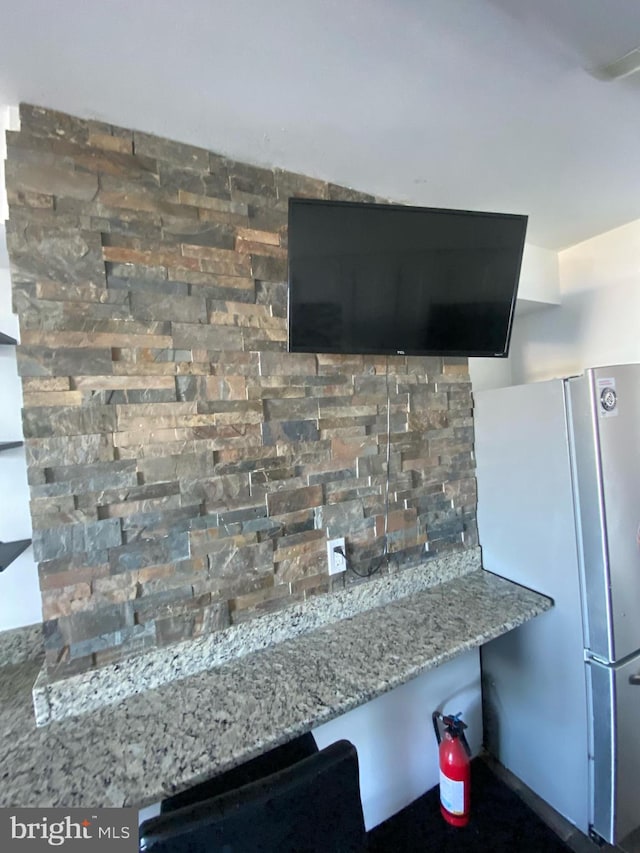 interior details with light stone counters and white refrigerator