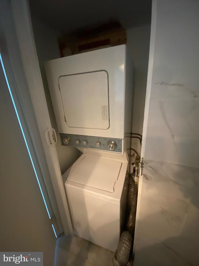 laundry room with stacked washing maching and dryer and laundry area