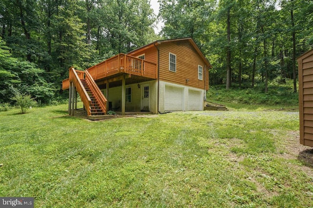 rear view of property with a deck, a garage, and a lawn