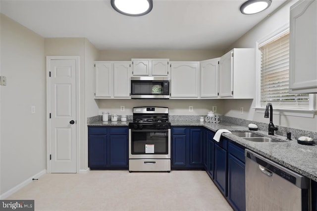 kitchen with appliances with stainless steel finishes, blue cabinetry, white cabinets, and sink