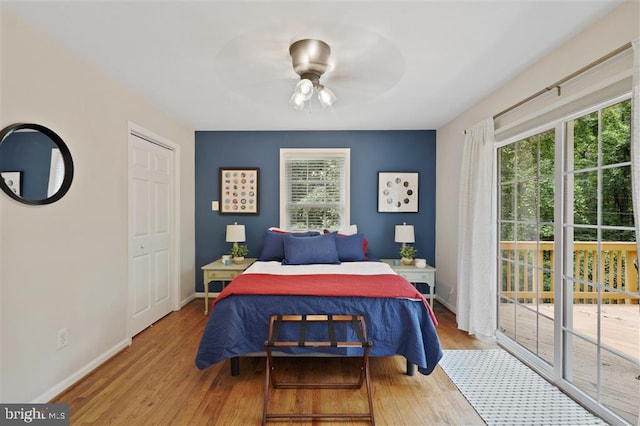 bedroom featuring hardwood / wood-style flooring, multiple windows, and ceiling fan