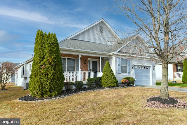 view of front of house featuring covered porch, a garage, and a front yard