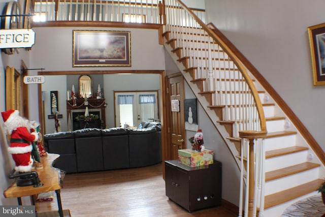 interior space featuring a high ceiling, hardwood / wood-style flooring, and french doors