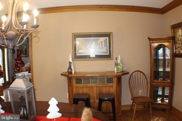 dining space featuring crown molding, wood-type flooring, indoor bar, and a notable chandelier