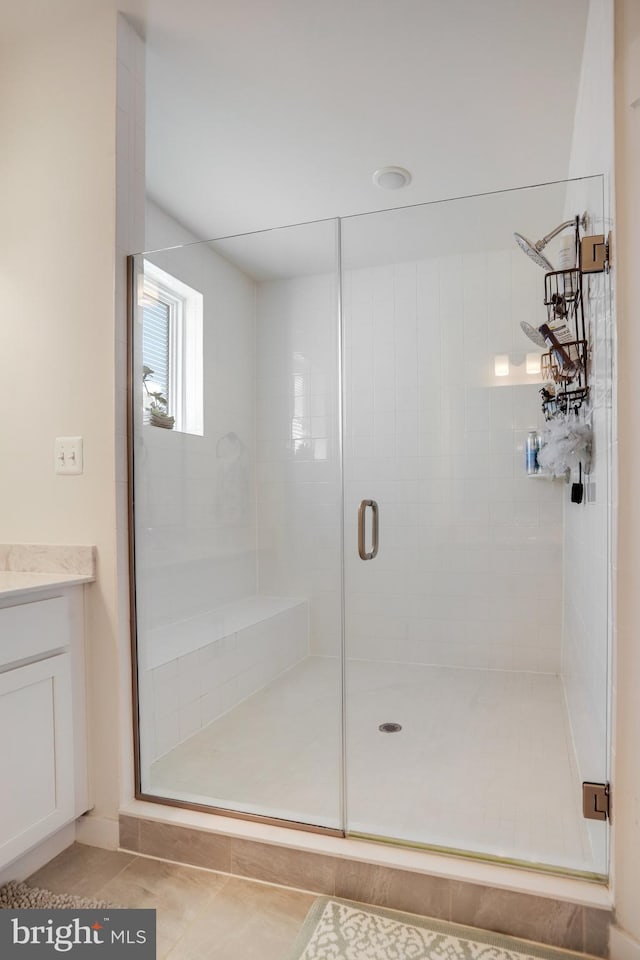 bathroom featuring vanity, an enclosed shower, and tile patterned floors