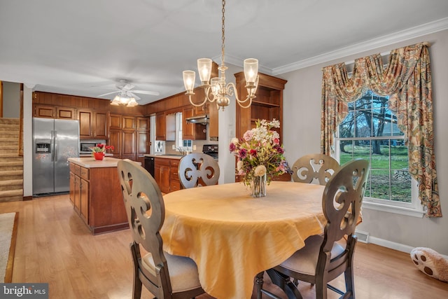 dining space with ornamental molding, sink, light hardwood / wood-style floors, and ceiling fan with notable chandelier