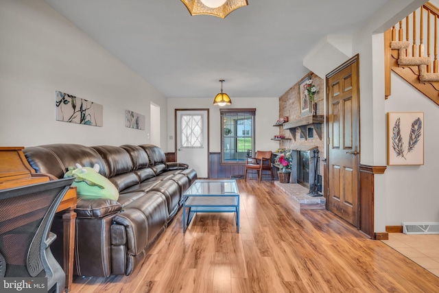 living room featuring light hardwood / wood-style floors and a brick fireplace