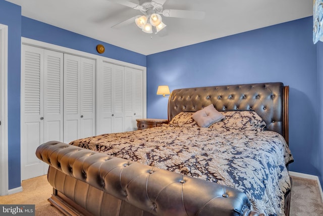 carpeted bedroom featuring two closets and ceiling fan