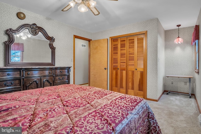 carpeted bedroom featuring a closet and ceiling fan