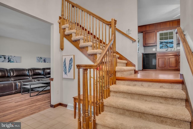 stairway with sink and hardwood / wood-style floors