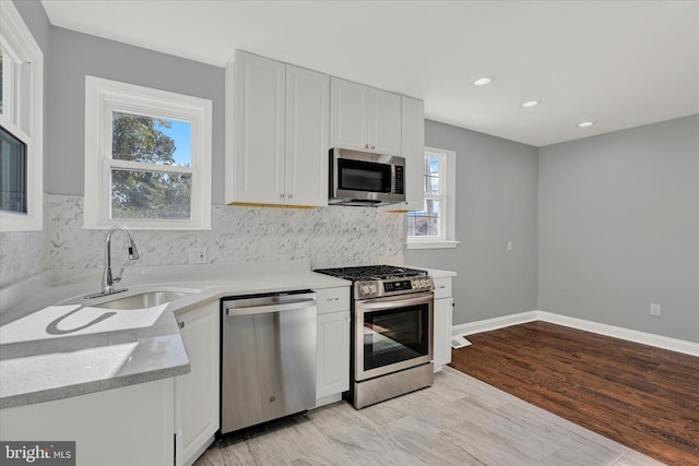 kitchen with white cabinetry, a healthy amount of sunlight, and appliances with stainless steel finishes