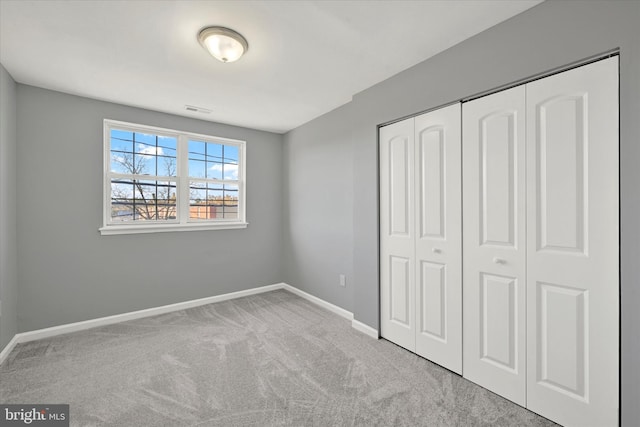 unfurnished bedroom featuring a closet and light colored carpet