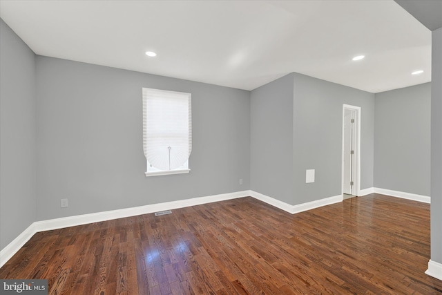 unfurnished room with dark hardwood / wood-style flooring