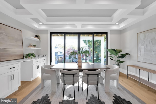 dining space featuring light wood-type flooring and coffered ceiling