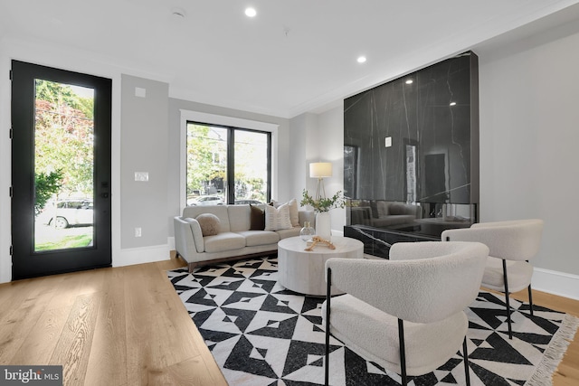living area featuring baseboards, light wood finished floors, and recessed lighting