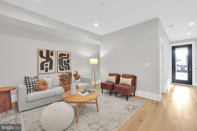 living area featuring baseboards, light wood finished floors, recessed lighting, and visible vents