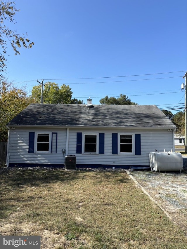 view of front of home with a front lawn and central AC