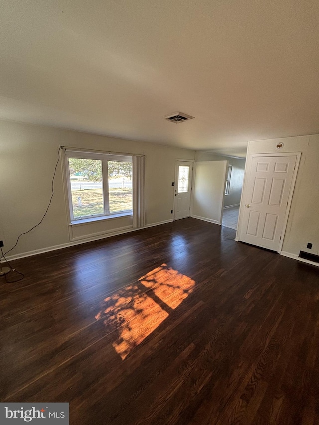 unfurnished living room with dark wood-type flooring