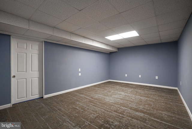 basement featuring a drop ceiling and dark hardwood / wood-style floors