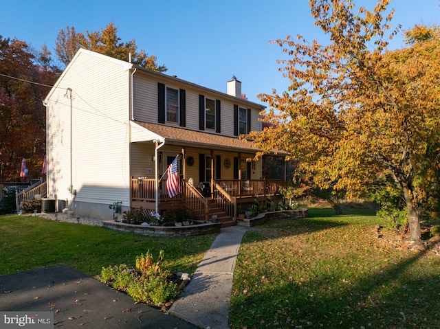 view of front of house featuring a front lawn, central AC unit, and a porch