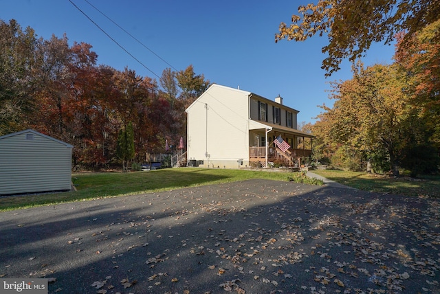 view of side of home with a porch and a yard