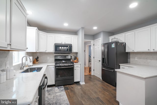 kitchen with sink, dark hardwood / wood-style flooring, white cabinetry, stainless steel appliances, and decorative backsplash