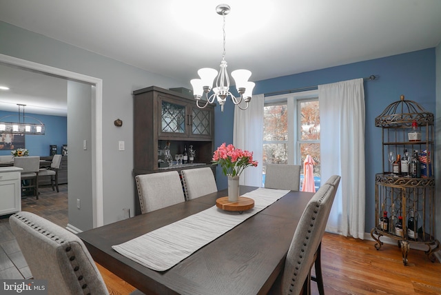 dining area with an inviting chandelier and hardwood / wood-style floors