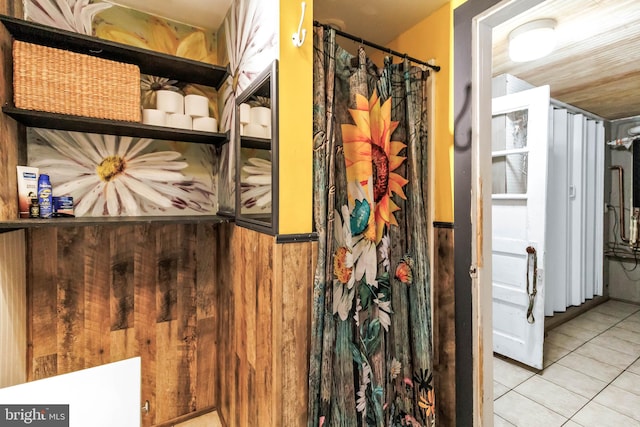 bathroom featuring wooden walls and tile patterned flooring