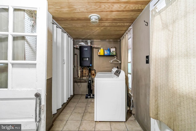 laundry area featuring wood ceiling, wooden walls, washer and clothes dryer, and light tile patterned floors