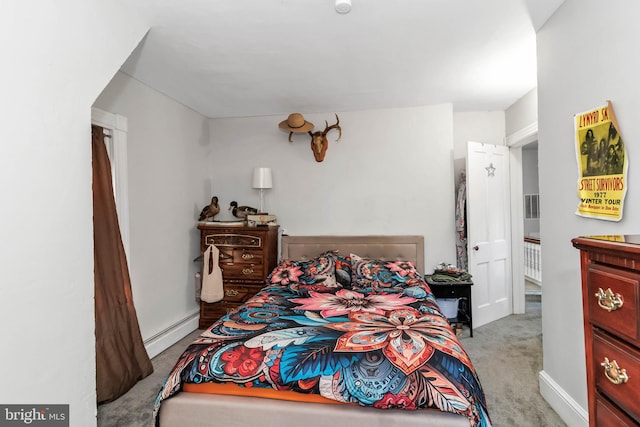 bedroom featuring light carpet and a baseboard heating unit