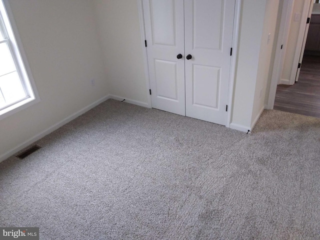 unfurnished bedroom with carpet and a closet