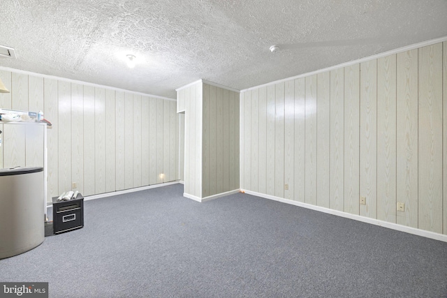 basement featuring wood walls, a textured ceiling, and dark carpet