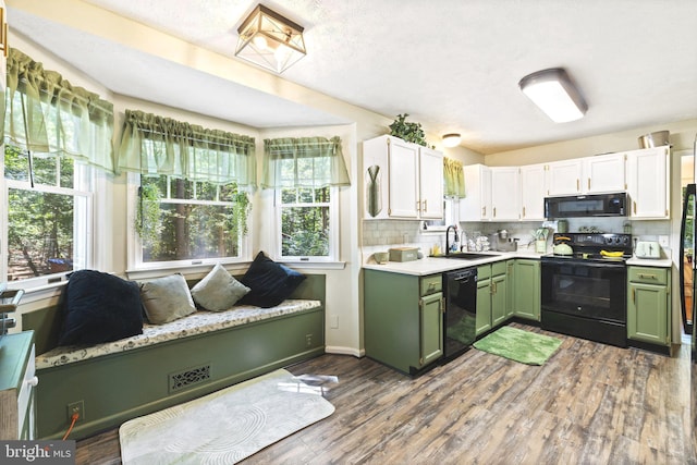 kitchen featuring tasteful backsplash, black appliances, sink, hardwood / wood-style floors, and white cabinets