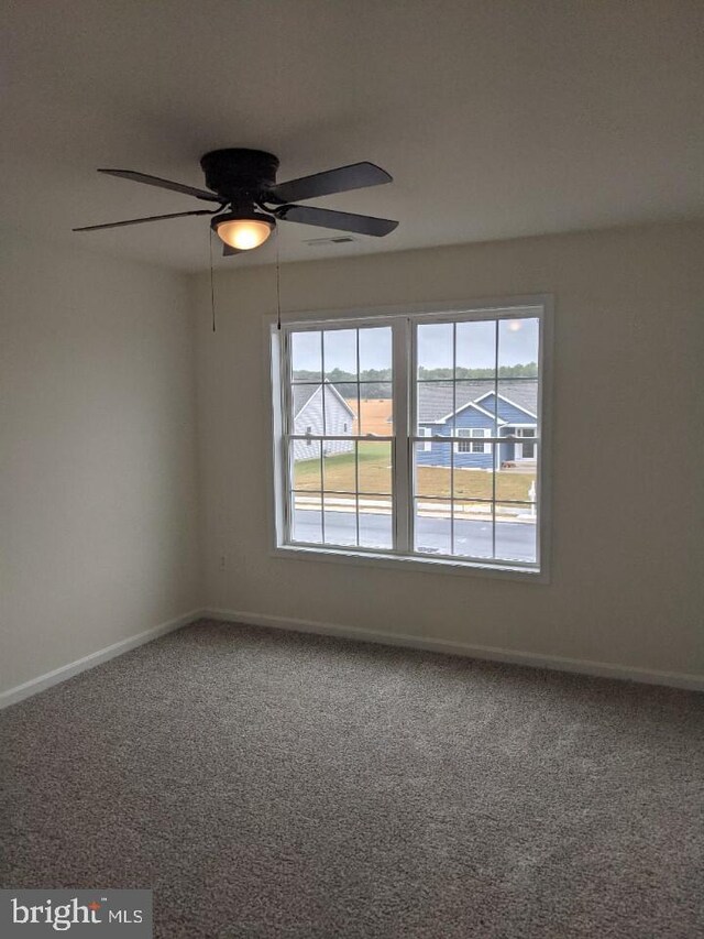 empty room with ceiling fan and carpet floors