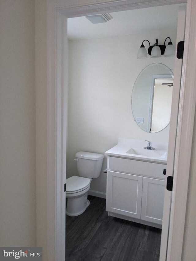 bathroom featuring hardwood / wood-style floors, vanity, and toilet