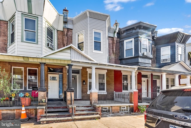 townhome / multi-family property with cooling unit and covered porch