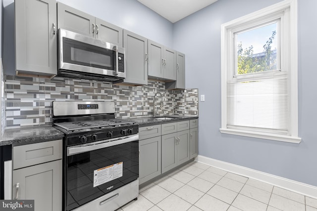 kitchen featuring stainless steel appliances, gray cabinets, light tile patterned floors, and sink